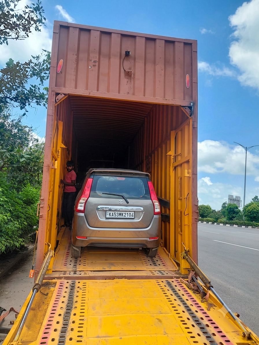 Car being loaded into a closed container truck